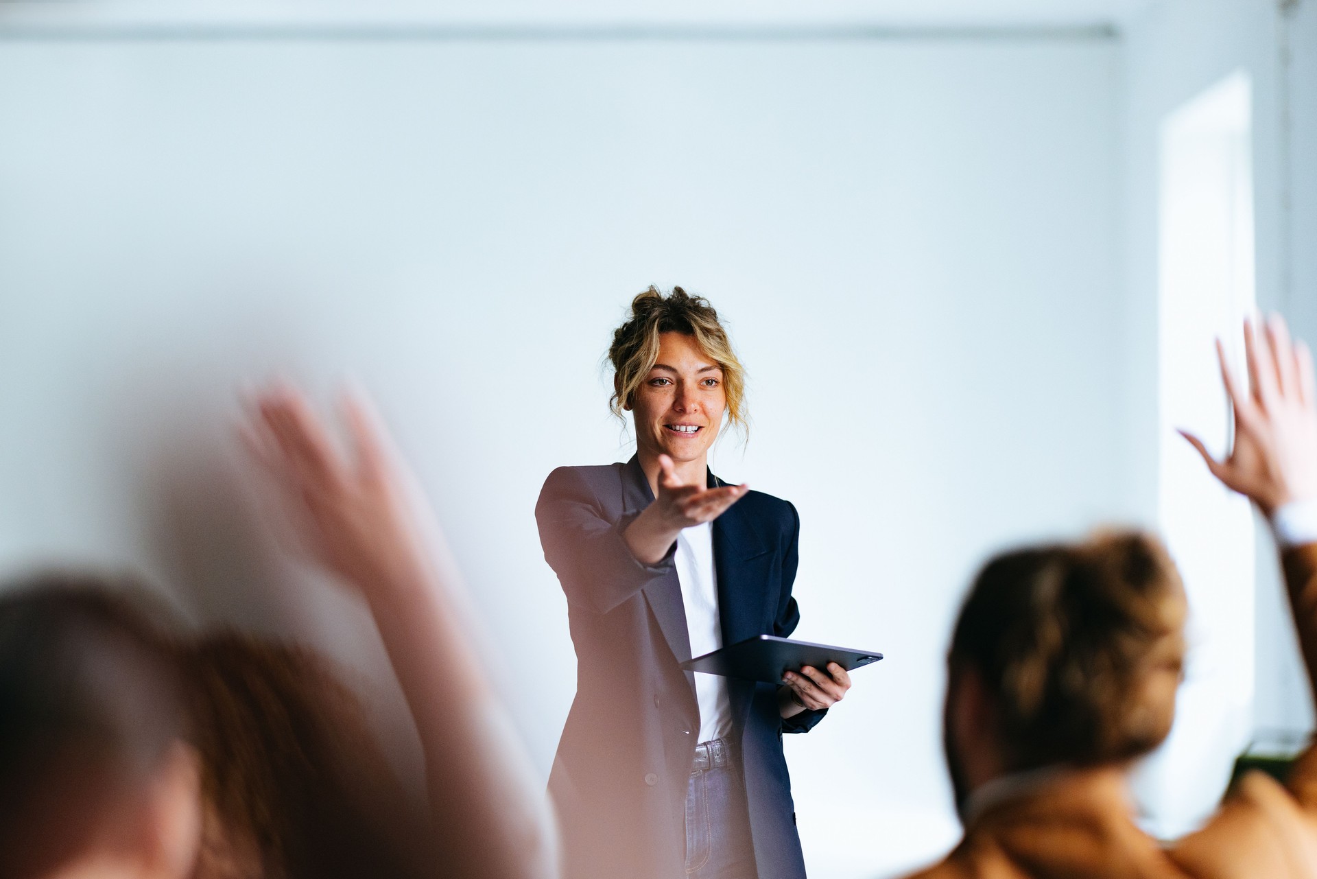 Smiling Business Woman Talking And Pointing To Audience During A Q And A Session